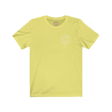 Load image into Gallery viewer, Light yellow t-shirt with a Mystical Pixel logo on the left side of the chest. There is a purple version of the logo where the tag of the shirt usually would be.