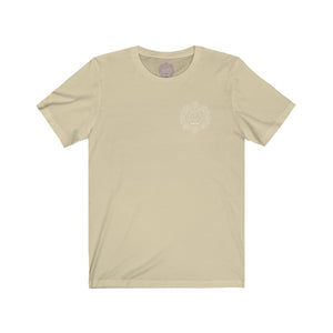 Tan t-shirt with a Mystical Pixel logo on the left side of the chest. There is a purple version of the logo where the tag of the shirt usually would be.
