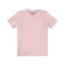 Load image into Gallery viewer, Soft pink t-shirt with a Mystical Pixel logo on the left side of the chest. There is a purple version of the logo where the tag of the shirt usually would be.